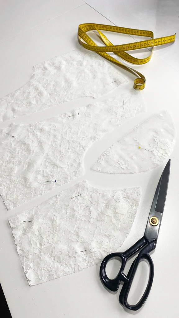 Schneiderservice, ein Maßband , Schere und Stoffstücke auf dem Tisch